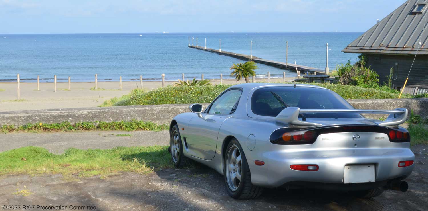 青い空と海に続く桟橋とRX-7(FD3S)の写真