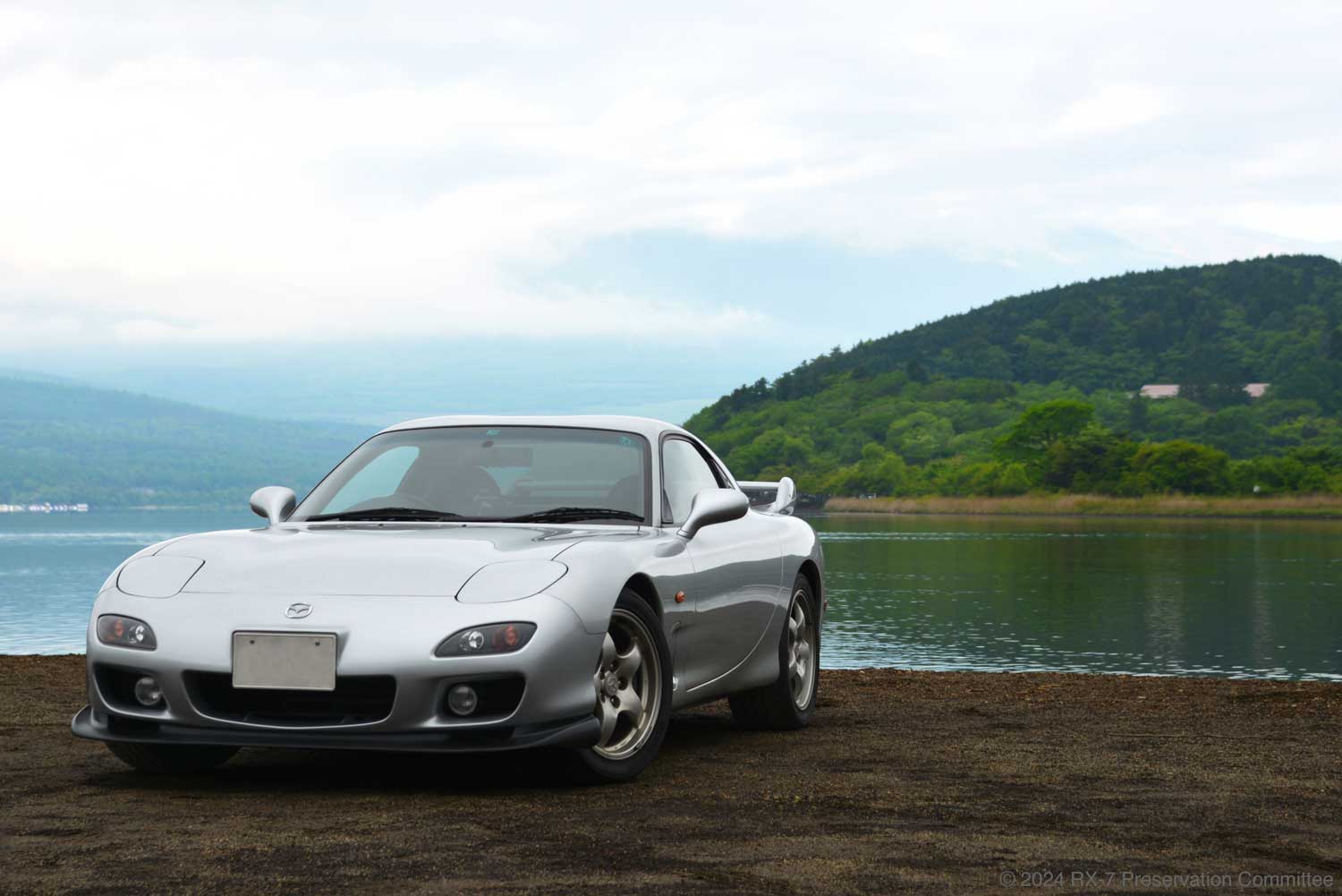 曇り空と湖を背景にしたRX-7(FD3S)の写真