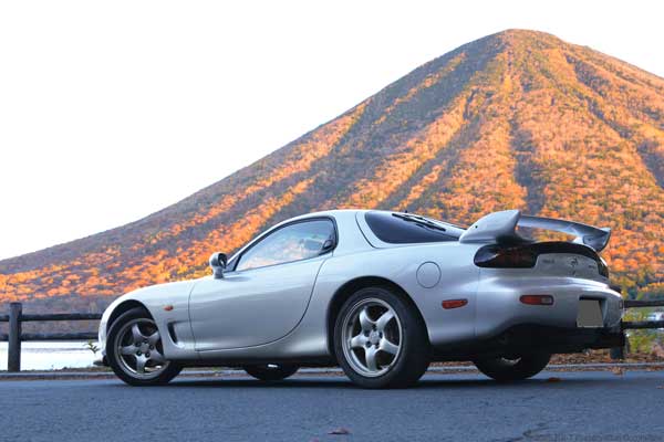 朝日を浴びる山とRX-7(FD3S)の写真